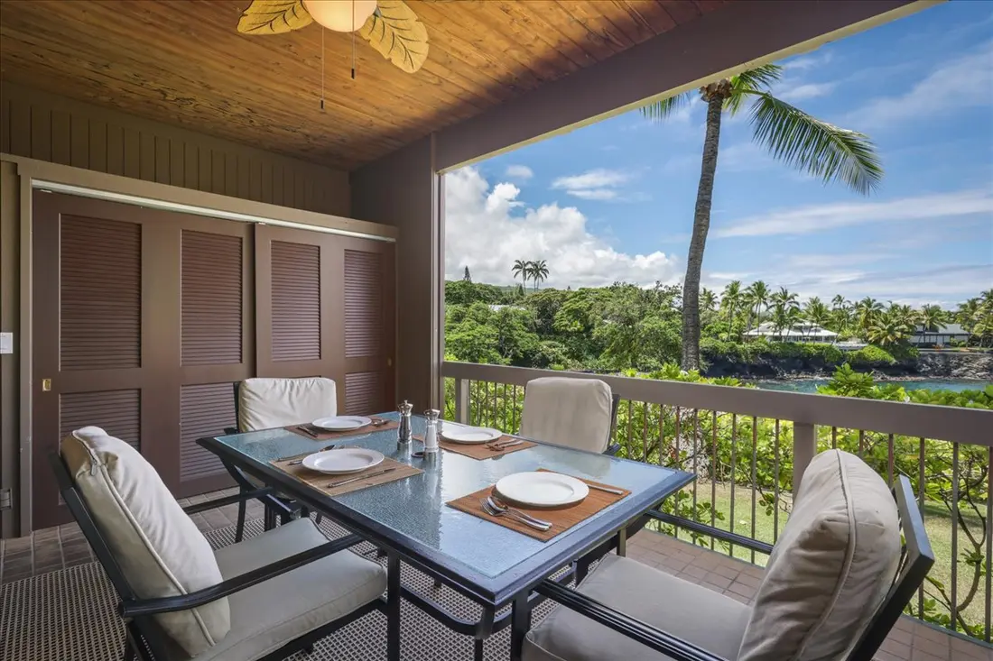 Lanai table framed by palms and blue sky