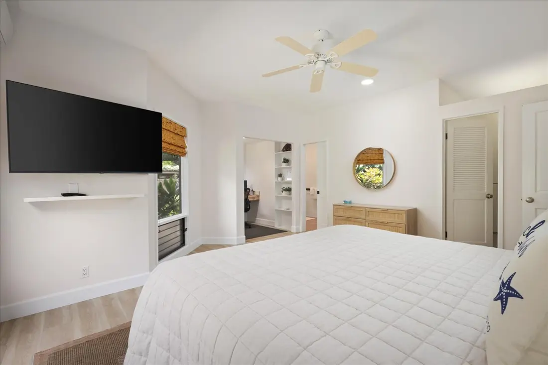 Primary bedroom showing television and ensuite entrance