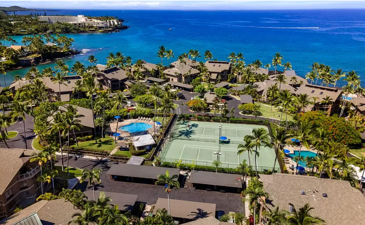 Aerial view of Kanaloa at Kona showing pools, courts, buildings and ocean